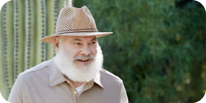 Image of Dr. Andrew Weil standing outside with a cactus behind him