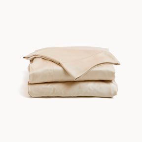 Image showcasing entire Ivory Recovery Viscose Sheet Set all neatly folded on top of one another with a white background. The image shows (from top to bottom): pillowcase, flat sheet, fitted sheet