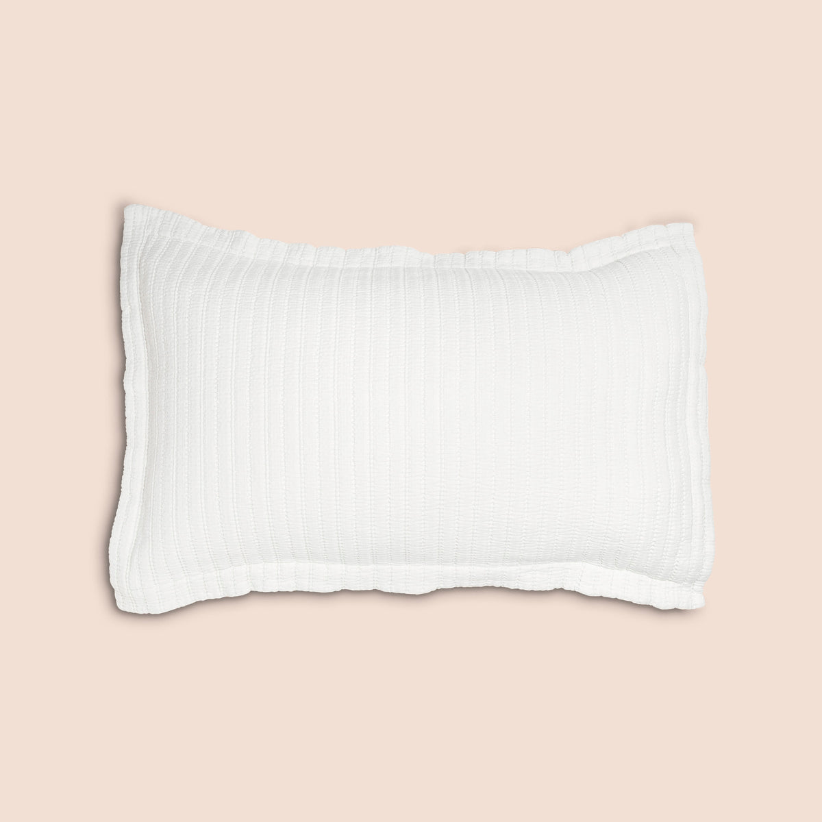 Image of the Ecru Ridgeback Pillow Sham featured on a pillow with a light pink background