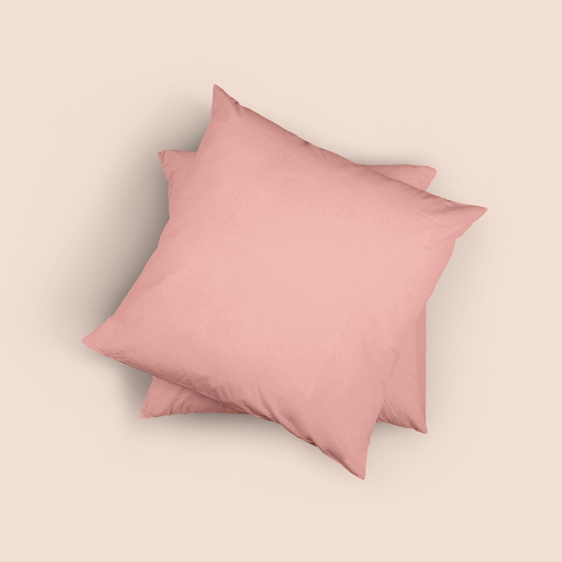 Image of the top of the Pink Sandstone Euro-sized Garment Washed Percale Pillow Sham on two Euro pillows stacked on top of one another with a light pink background