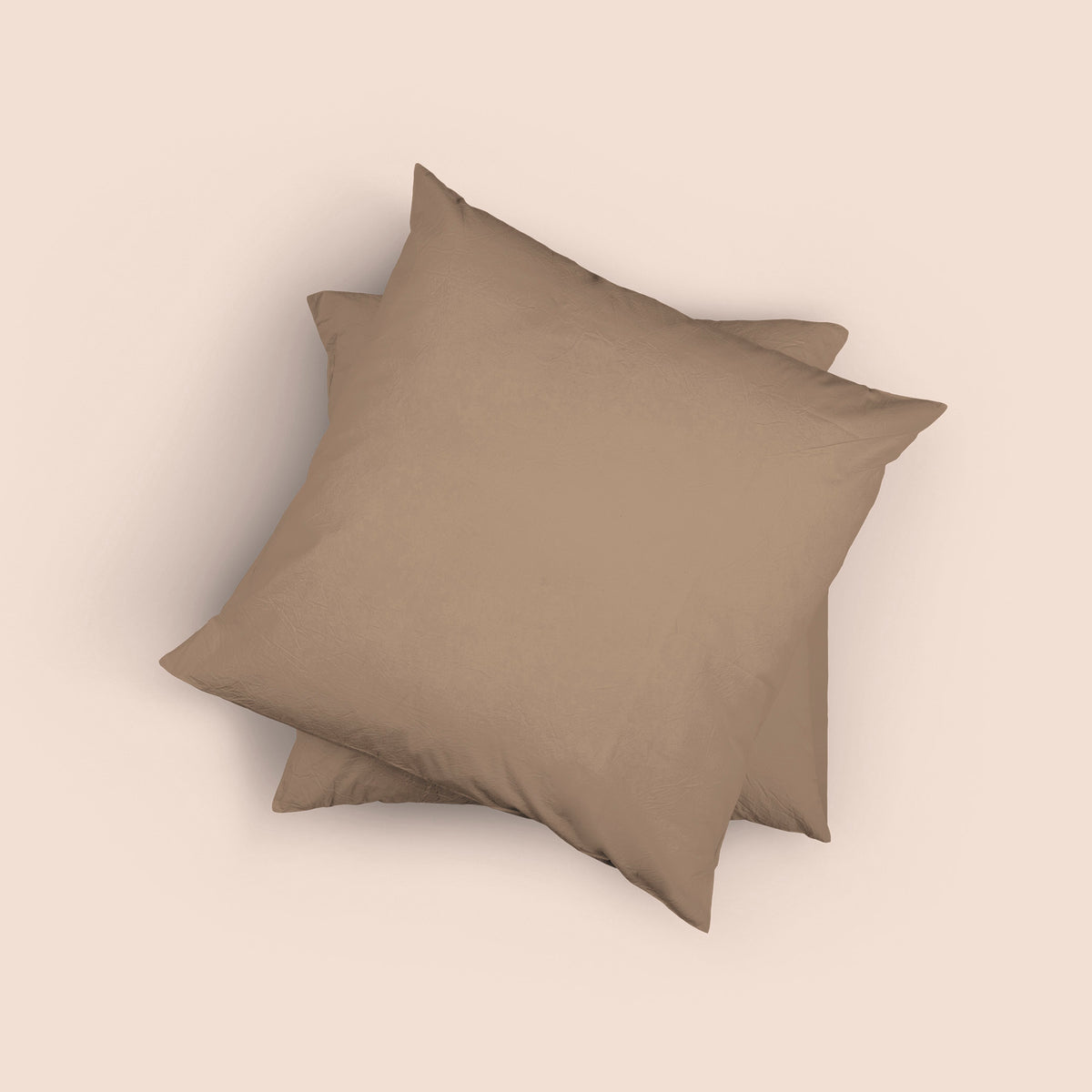 Image of the top of the Desert Sand Euro-sized Garment Washed Percale Pillow Sham on two Euro pillows stacked on top of one another with a light pink background