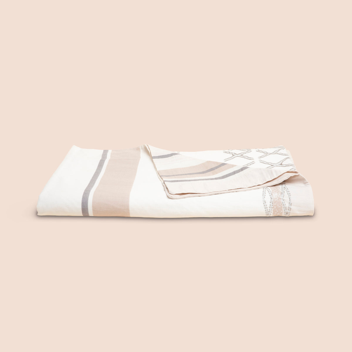 Image of a neatly folded Sonoran Duvet Cover with the back right corner folded forward on a light pink background