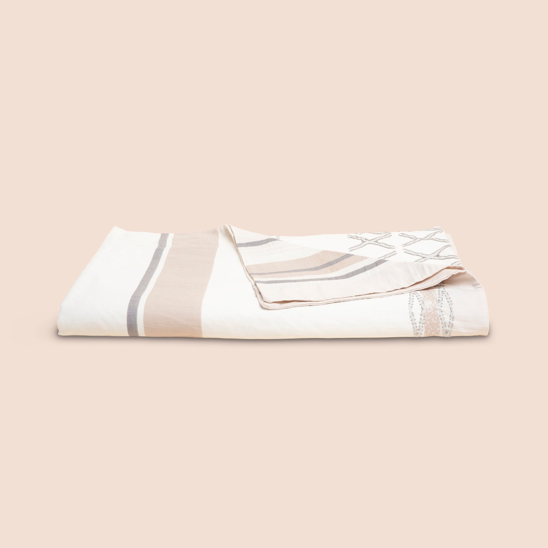 Image of a neatly folded Sonoran Duvet Cover with the back right corner folded forward on a light pink background
