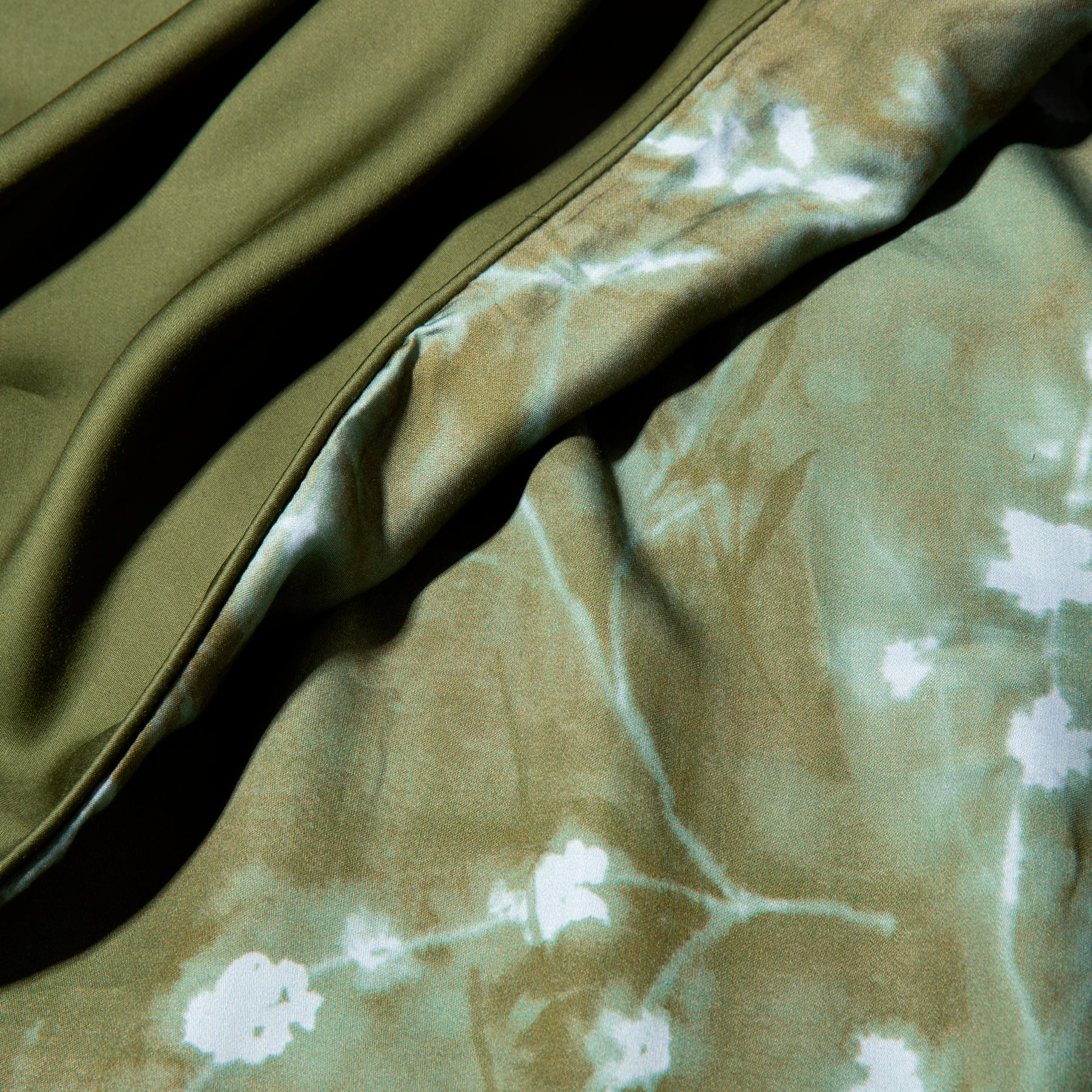 Close-up image of the Floral Evergreen Duvet Cover + Cooling showcasing both the Floral Evergreen side and the reversible plain Evergreen side