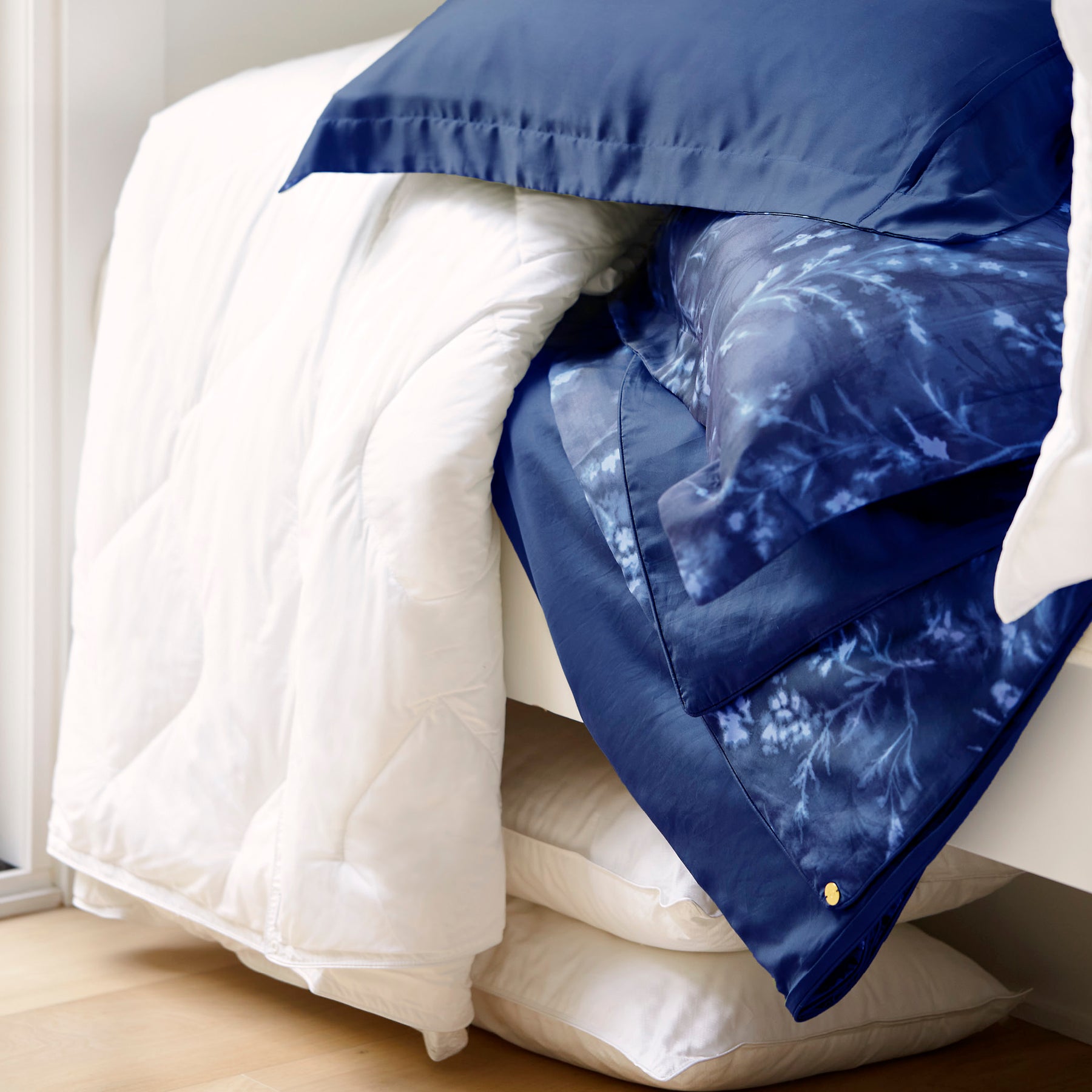 Image of various white bedding surrounding the reversible Floral Midnight Duvet Cover + Cooling and Pillow Shams