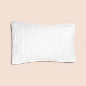 Image of the all-white side of the Heritage Pillow Sham on a pillow with a light pink background