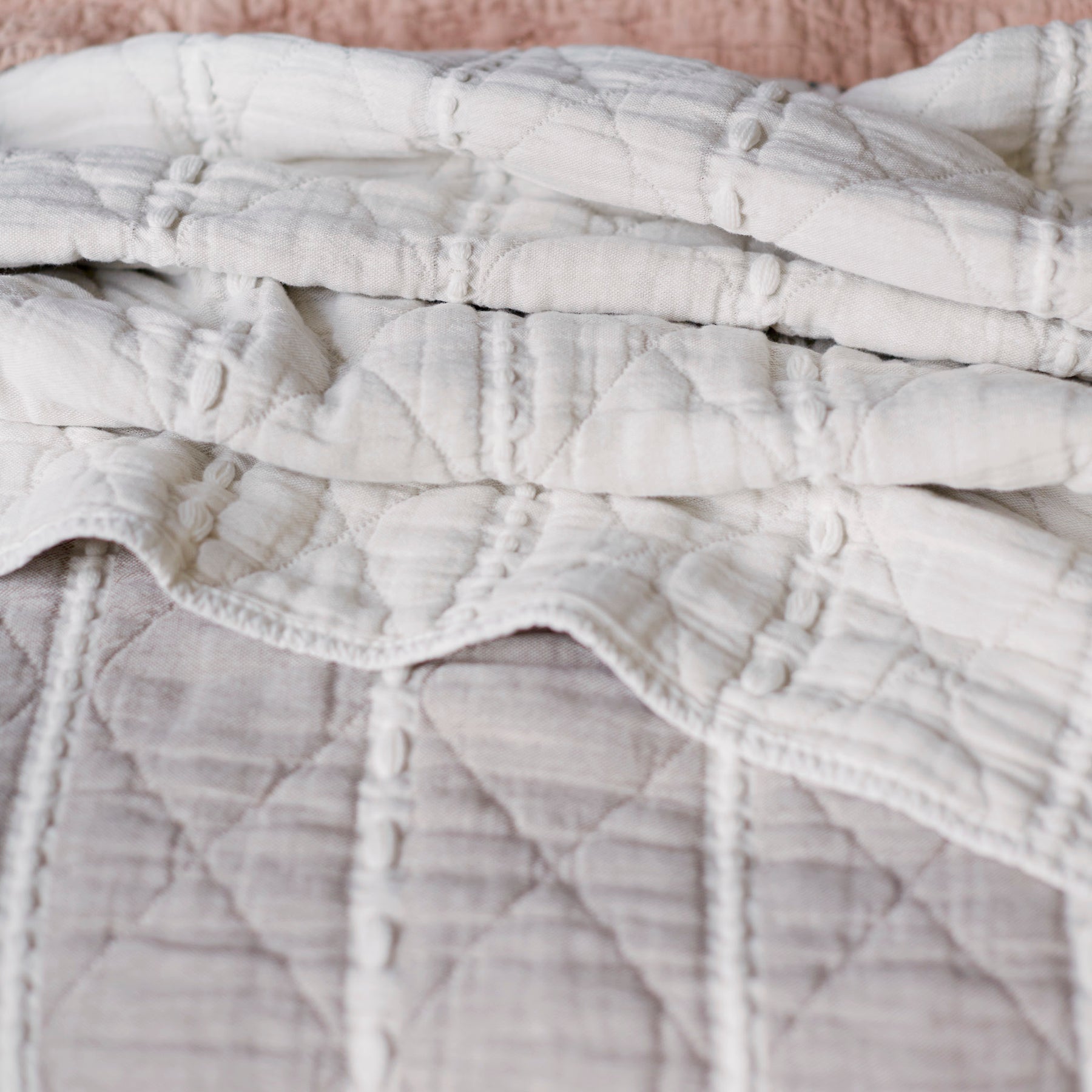 Close-up image showcasing both sides (gray and white striped and all-white) of the Heritage Quilt