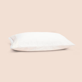 Image of the Signature Pillow Protector on a pillow with a light pink background