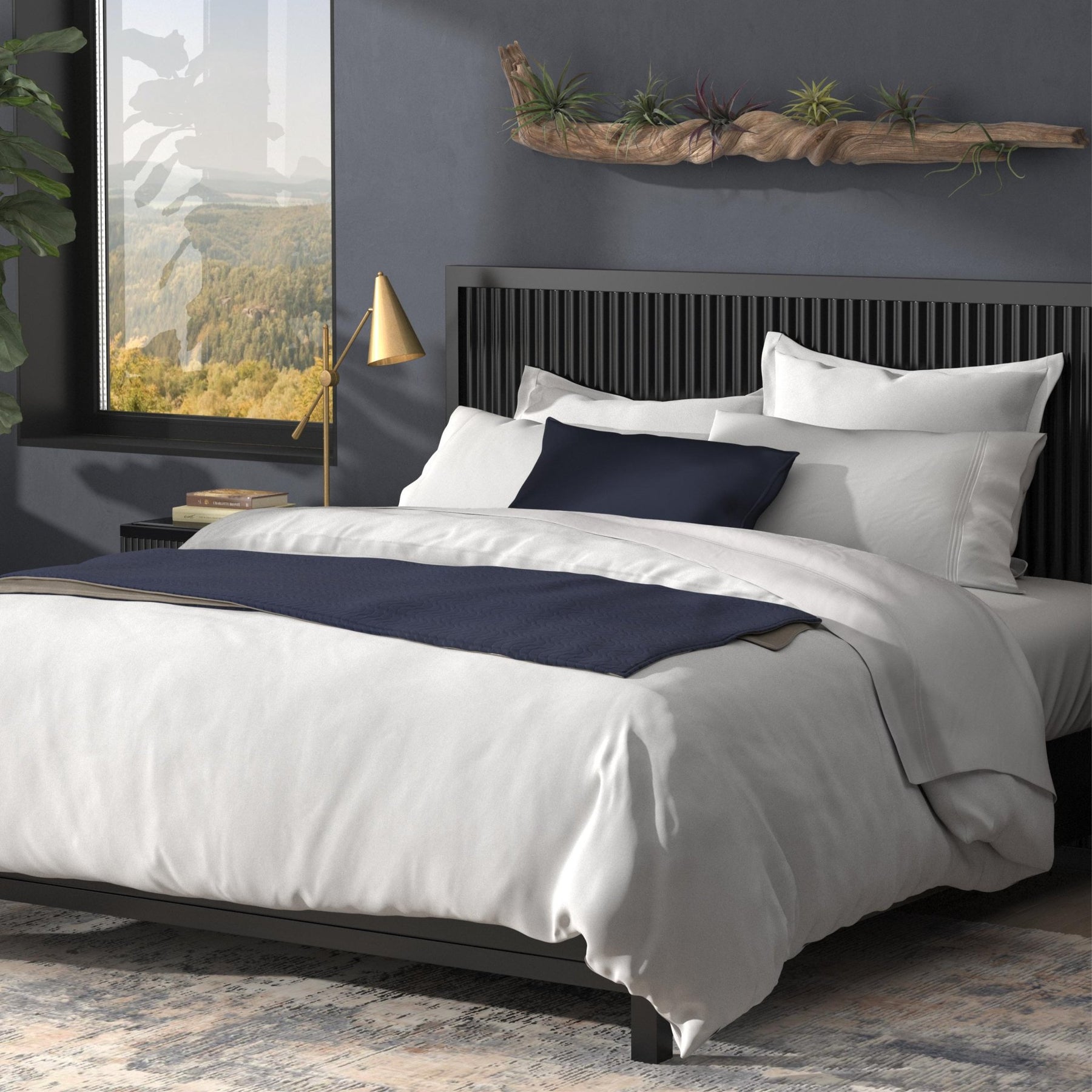 Image of a neatly made bed with white sheets and navy blue accents with the White Duvet Cover + Cooling on top