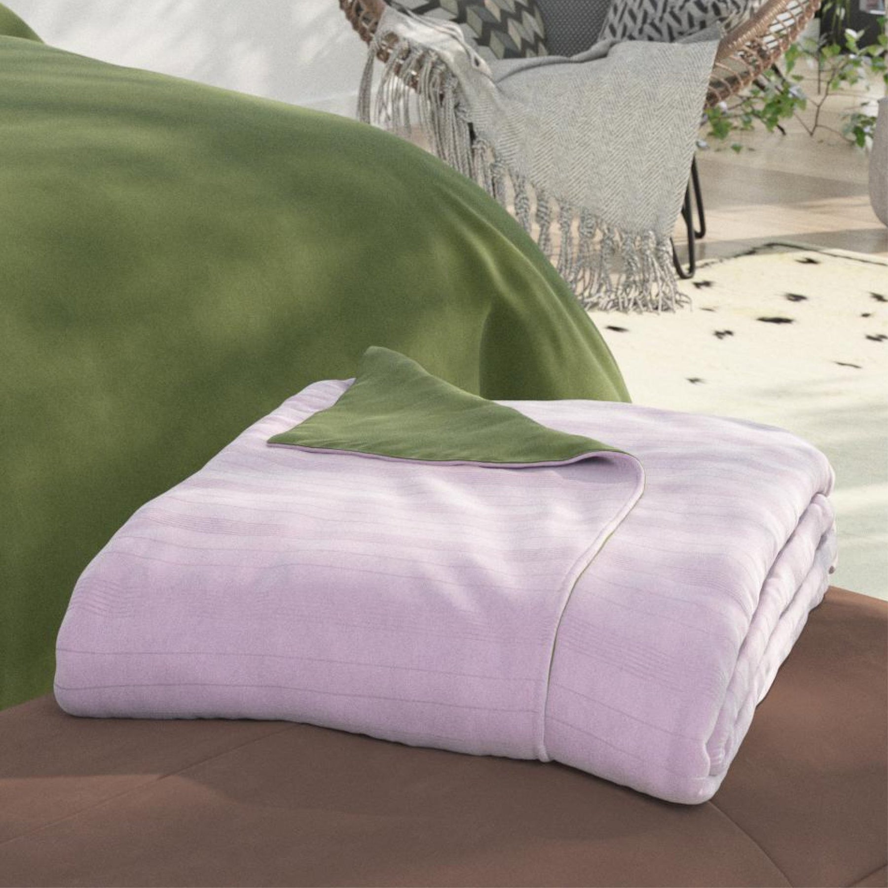 Image of a neatly folded Lilac/Jungle Duvet Cover + Cooling with the Lilac side facing up and a corner of the Jungle side folded back on a brown stool at the foot of a bed