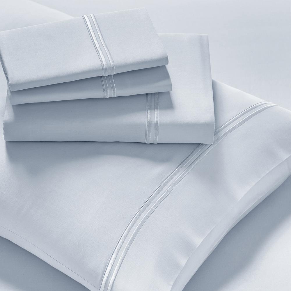 Image showcasing entire Light Blue Refreshing TENCEL™ Lyocell Sheet Set. The image includes: a fitted sheet on the bed, a pillowcase on a pillow, a neatly folded flat sheet, and two neatly folded pillowcases.