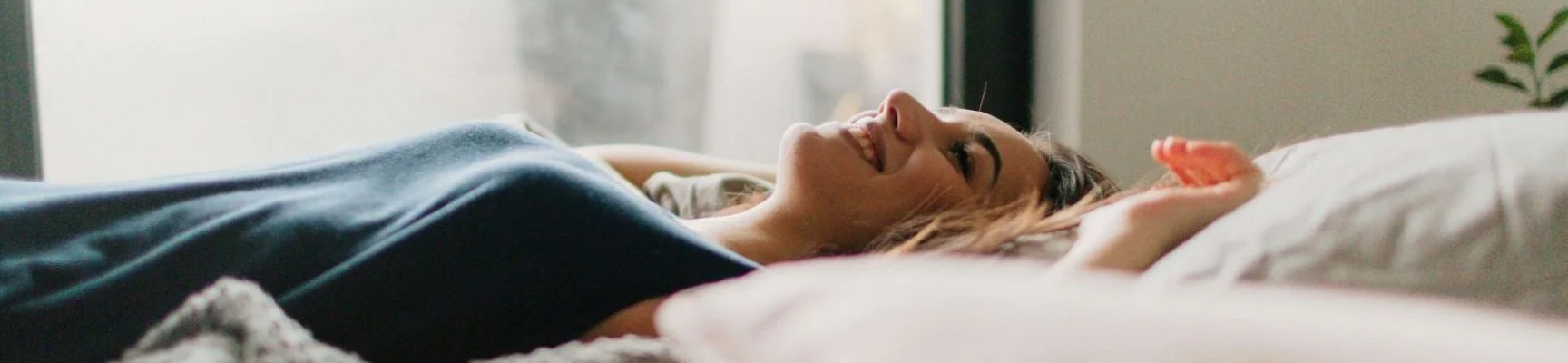 Image of a woman smiling lying in bed