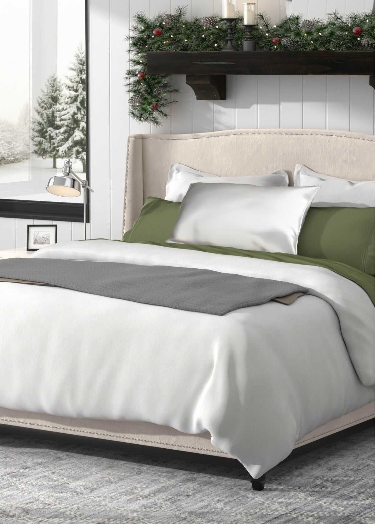 Image of a newly made bed with a White Duvet Cover + Cooling, gray blanket, Silver Pure Silk Pillowcase, and Moss Soft Touch TENCEL™ Modal Sheets with a wintery background. 