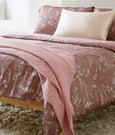 Image of a bed with a Floral Ash Rose Cooling Duvet Cover and Pillow Shams and an Ash Rose Everyday Cotton Coverlet