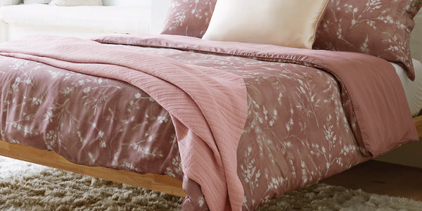 Image of a bed with a Floral Ash Rose Cooling Duvet Cover and Pillow Shams and an Ash Rose Everyday Cotton Coverlet
