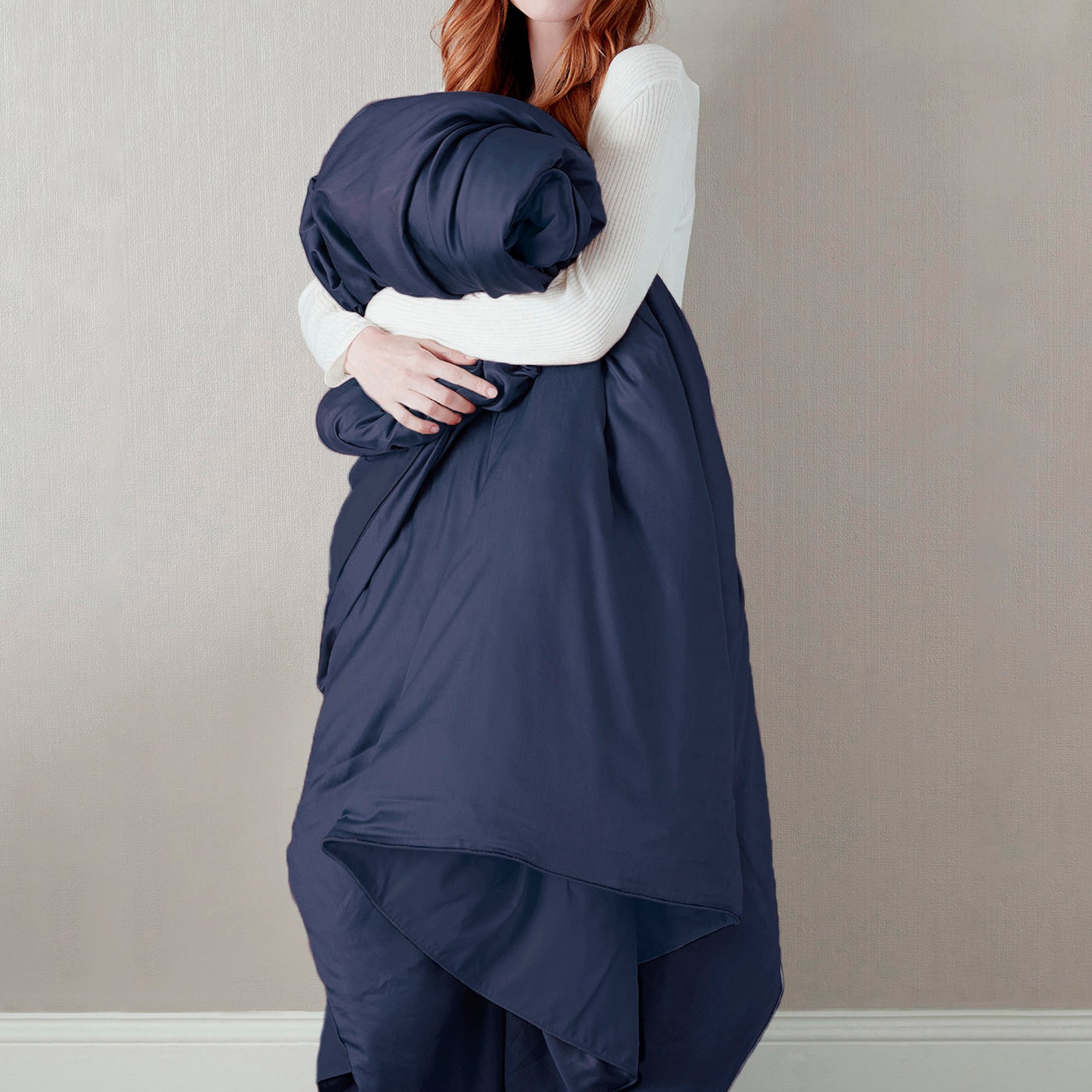 Image of a woman standing and holding the Midnight Soft Touch Duvet Cover against her