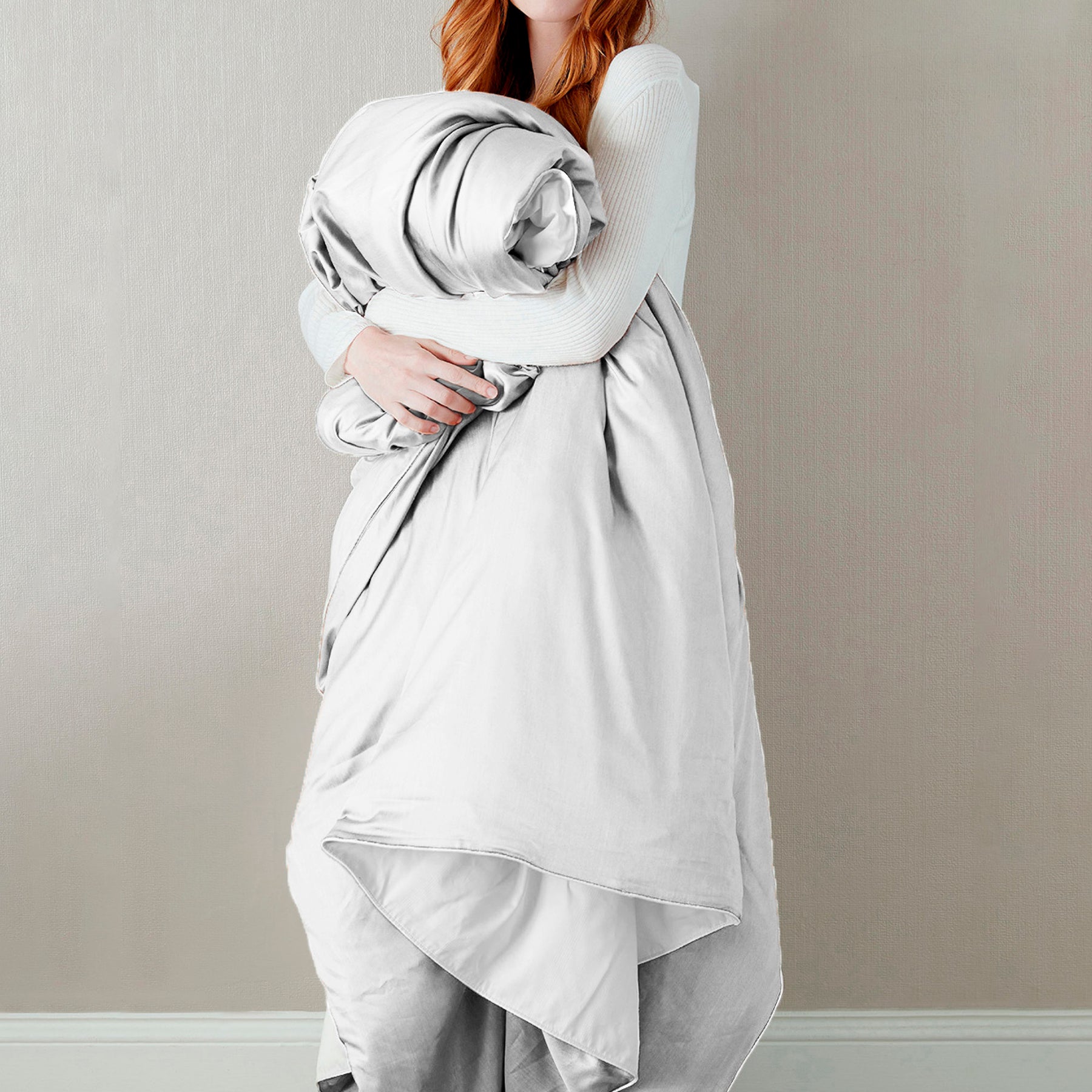 Image of a woman standing and holding the White Soft Touch Duvet Cover against her