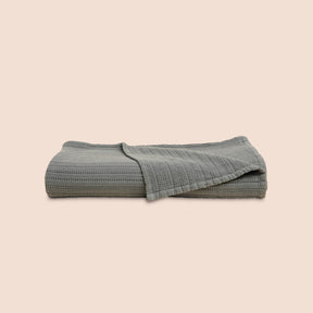 Image of a neatly folded Agave Ridgeback Coverlet with the back right corner folded forward