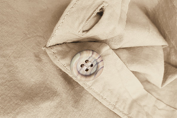 Close-up image of tan-colored duvet cover featuring the button enclosure feature