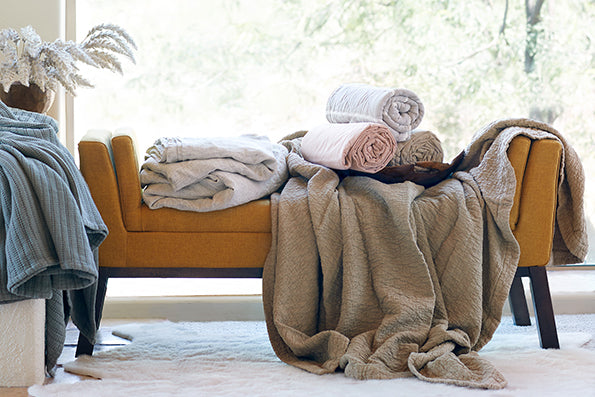 Image of an orange fabric bench with various fabrics and materials draping across
