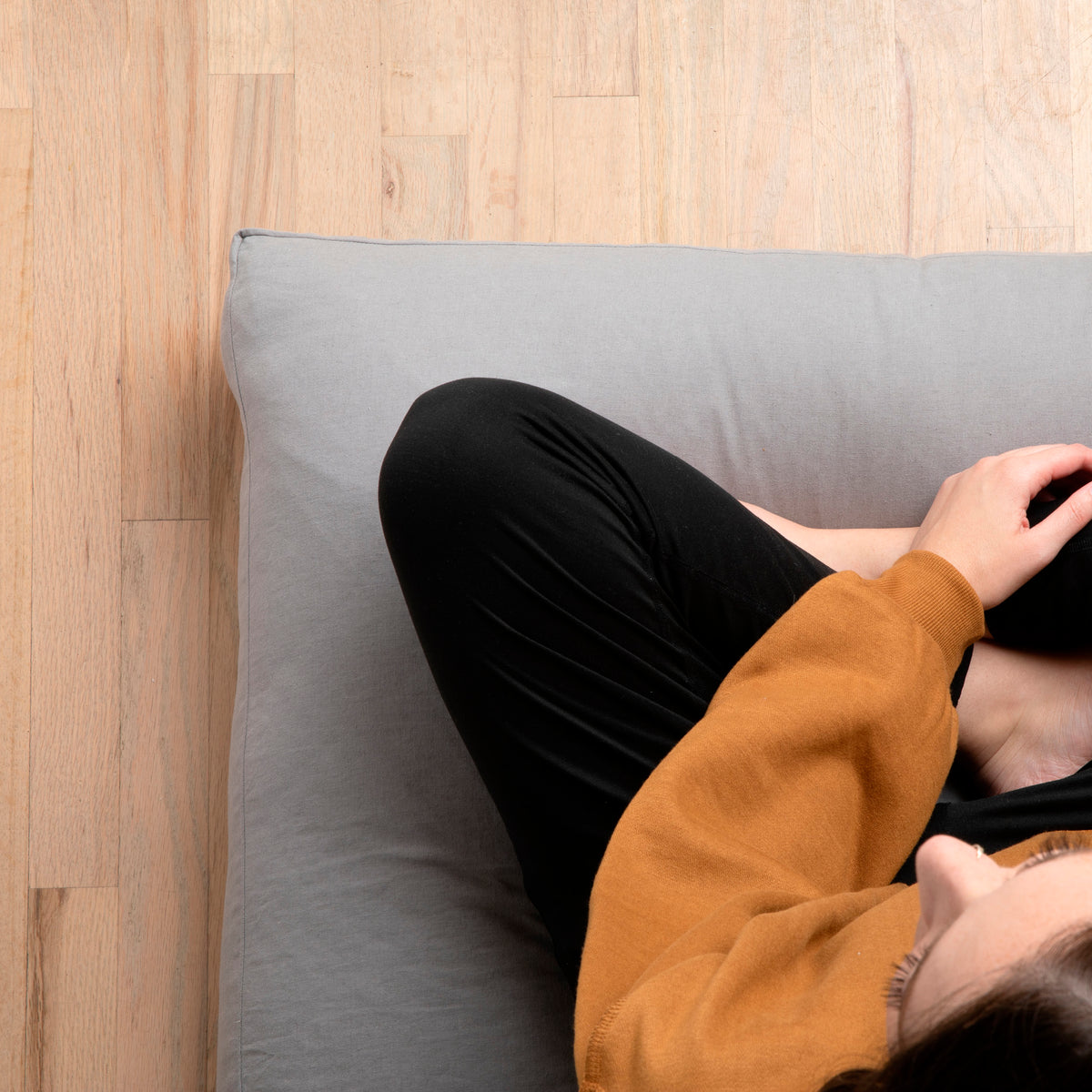 Image of woman sitting cross-legged on a meditation cushion with Stone Gray Blended Linen Meditation Cushion Cover