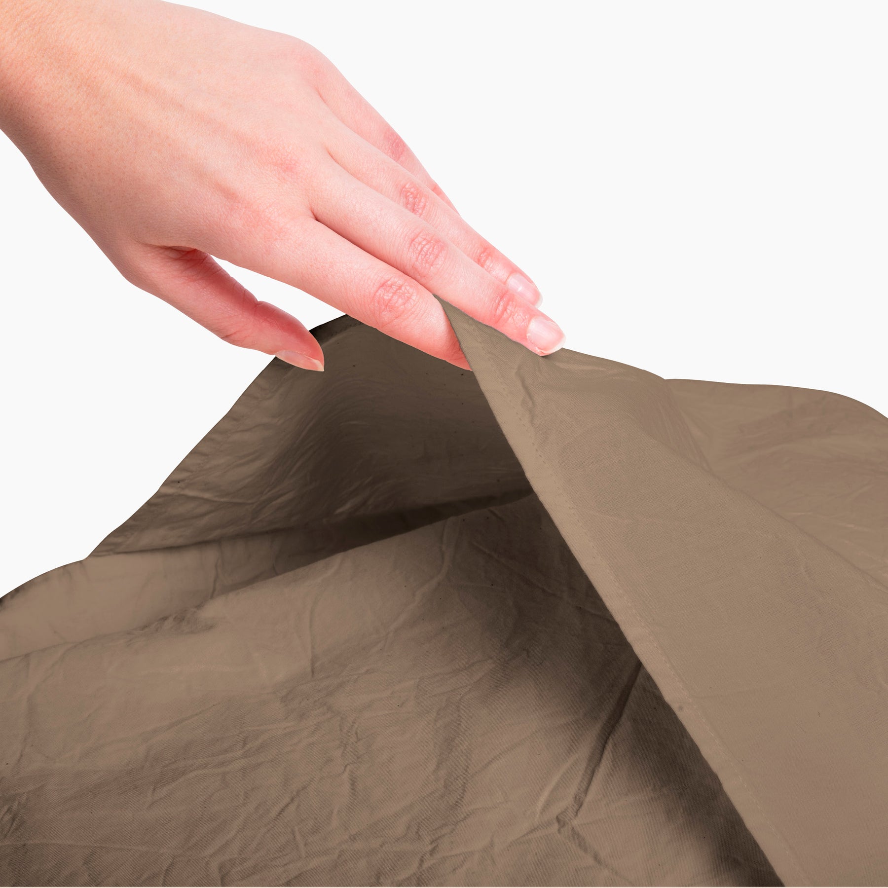 Image of a Desert Sand Garment Washed Percale Pillow Sham with a hand reaching down to open and showcase the enveloping design on the back