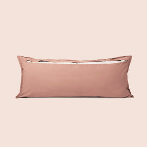 Image of the back of the Pink Sandstone Garment Washed Percale Lumbar Pillow Cover on a lumbar pillow with the back zipper open on a light pink background