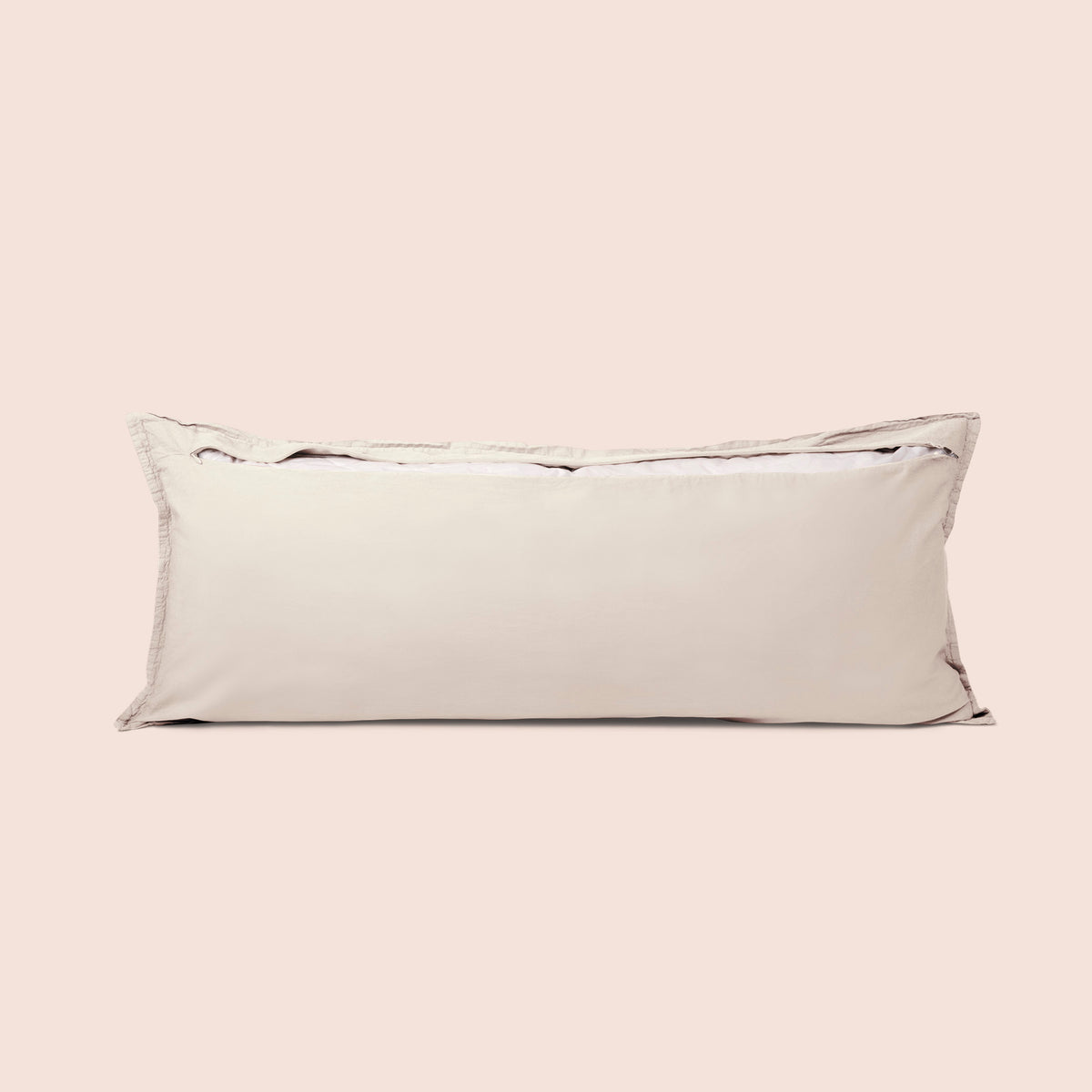Image of the back of the Ecru Garment Washed Percale Lumbar Pillow Cover on a lumbar pillow with the back zipper open on a light pink background