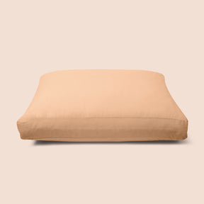Image of Ochre Garment Washed Percale Meditation Cushion Cover on a meditation cushion with a light pink background