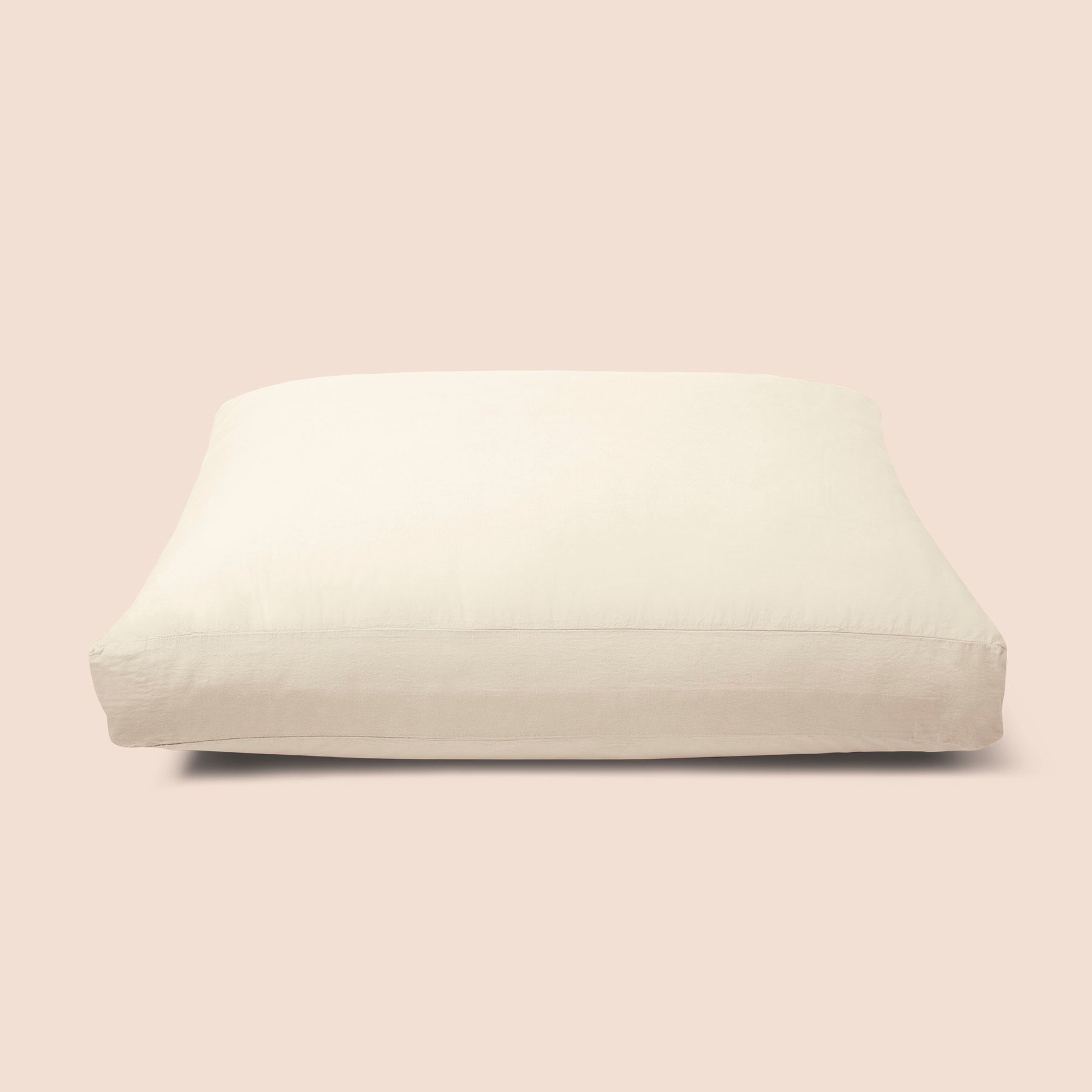 Image of Ecru Garment Washed Percale Meditation Cushion Cover on a meditation cushion with a light pink background