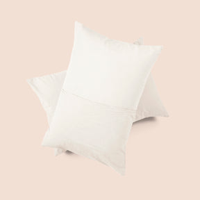 Image of the back of the Ecru Garment Washed Percale Pillow Sham on two pillows stacked on top of one another with a light pink background