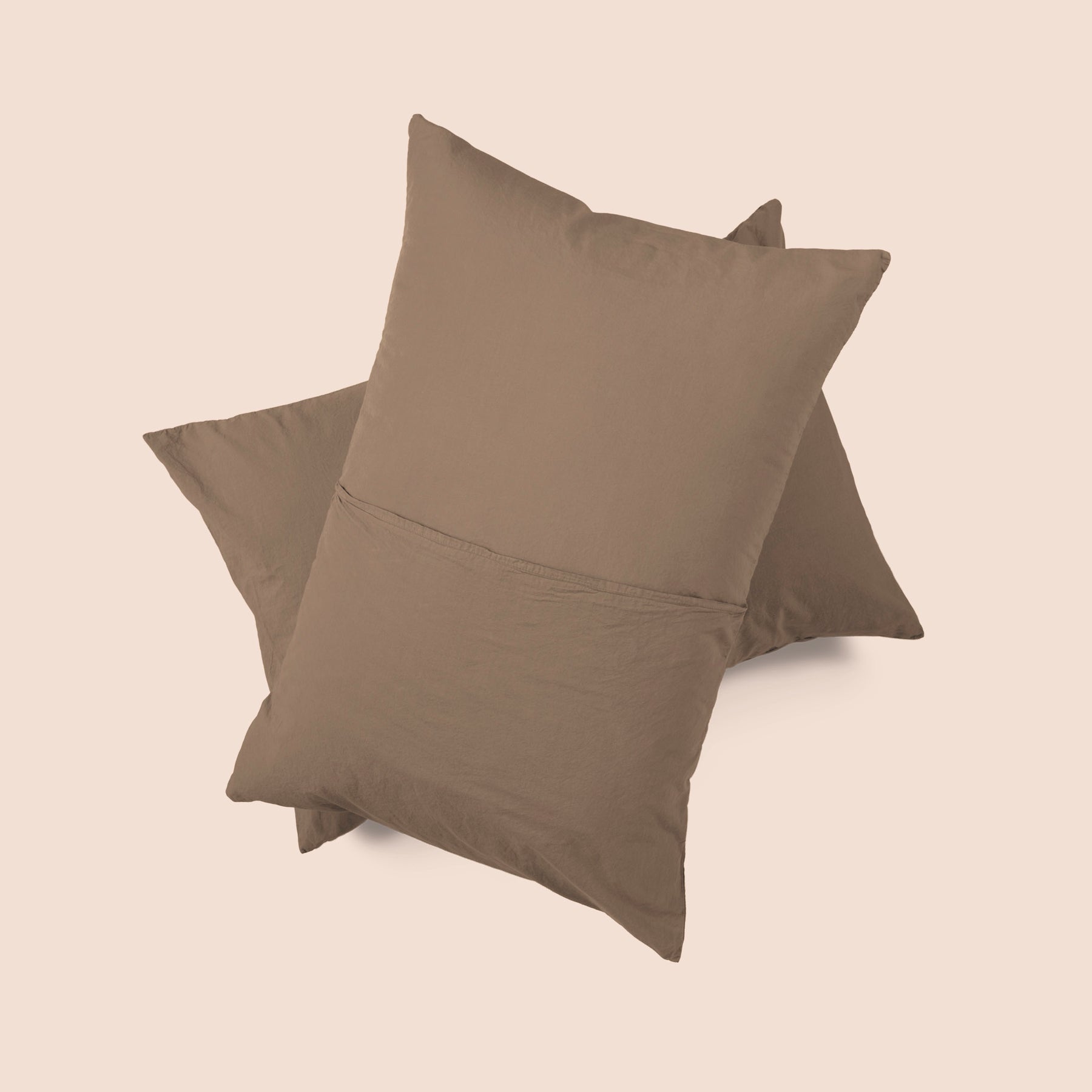 Image of the back of the Desert Sand Garment Washed Percale Pillow Sham on two pillows stacked on top of one another with a light pink background
