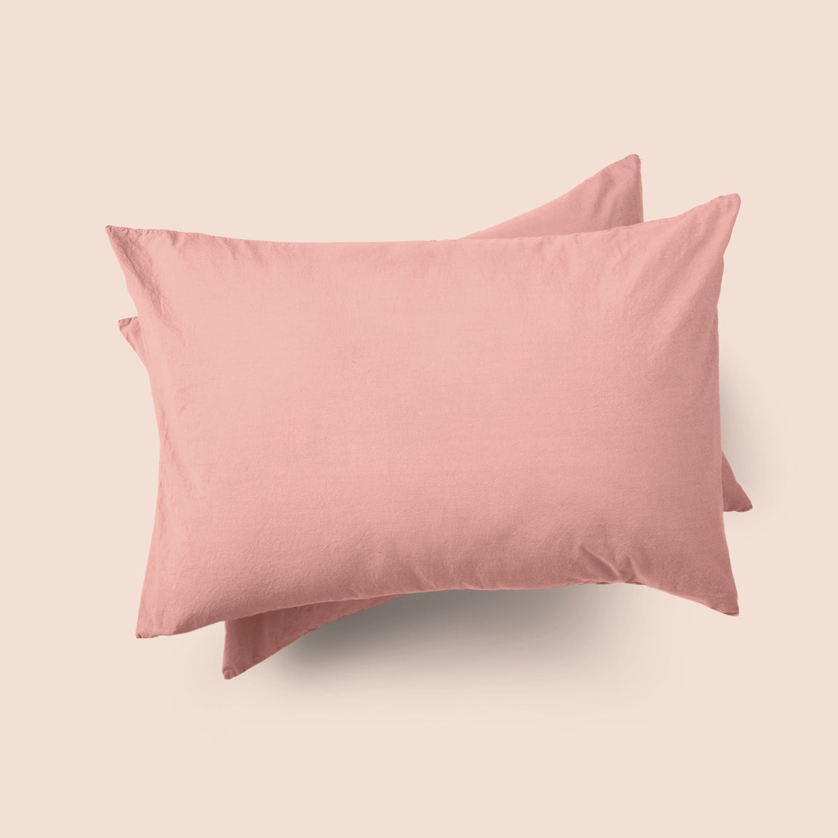 Image of the top of the Pink Sandstone Garment Washed Percale Pillow Sham on two pillows stacked on top of one another with a light pink background