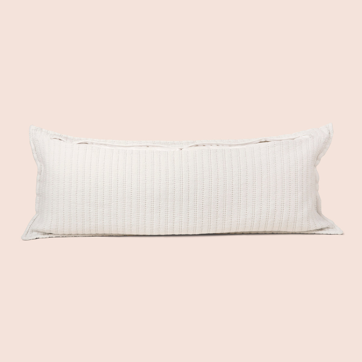 Image of the back of the Ecru Ridgeback Lumbar Pillow Cover on a lumbar pillow with the back zipper open on a light pink background