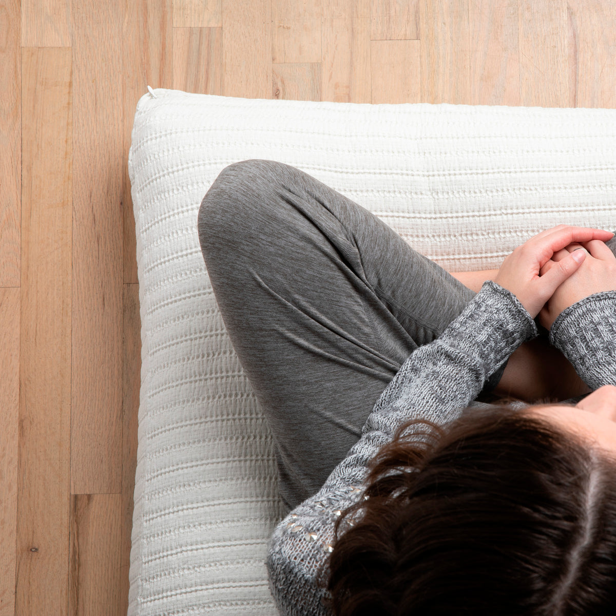 Image of woman sitting cross-legged on a meditation cushion with the Ecru Ridgeback Meditation Cushion Cover 