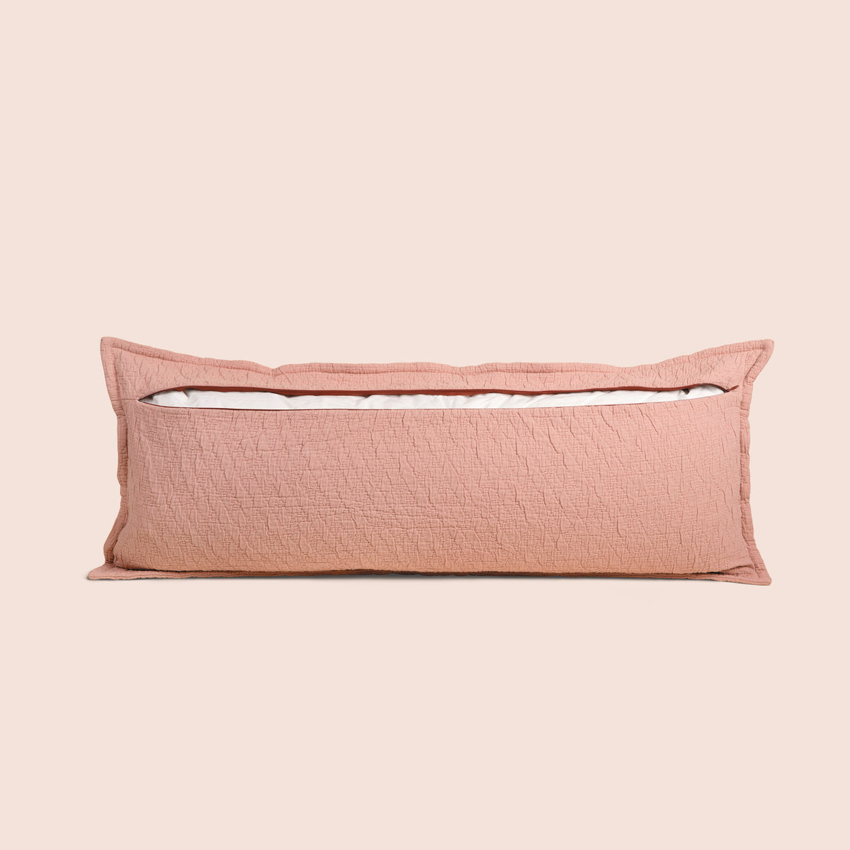 Image of the back of the Pink Sandstone Wave Lumbar Pillow Cover on a lumbar pillow with the back zipper open on a light pink background