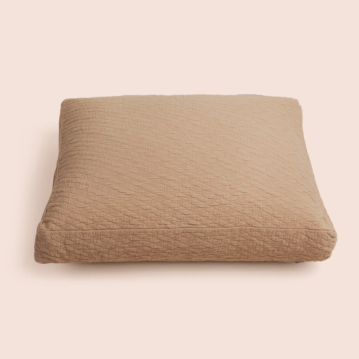 Image of the Ochre Wave Meditation Cushion Cover on a meditation cushion with a light pink background