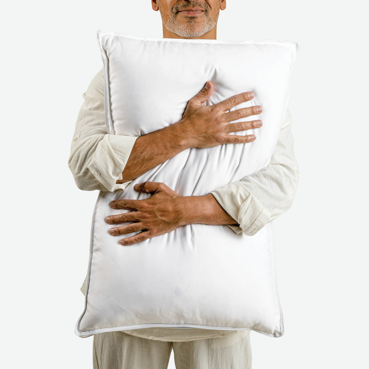 Image of a man hugging a Cooling Down Pillow against his upper body
