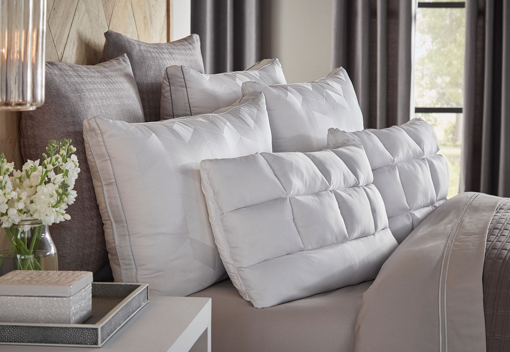 Image of the top of a bed with seven pillows of various shapes and sizes