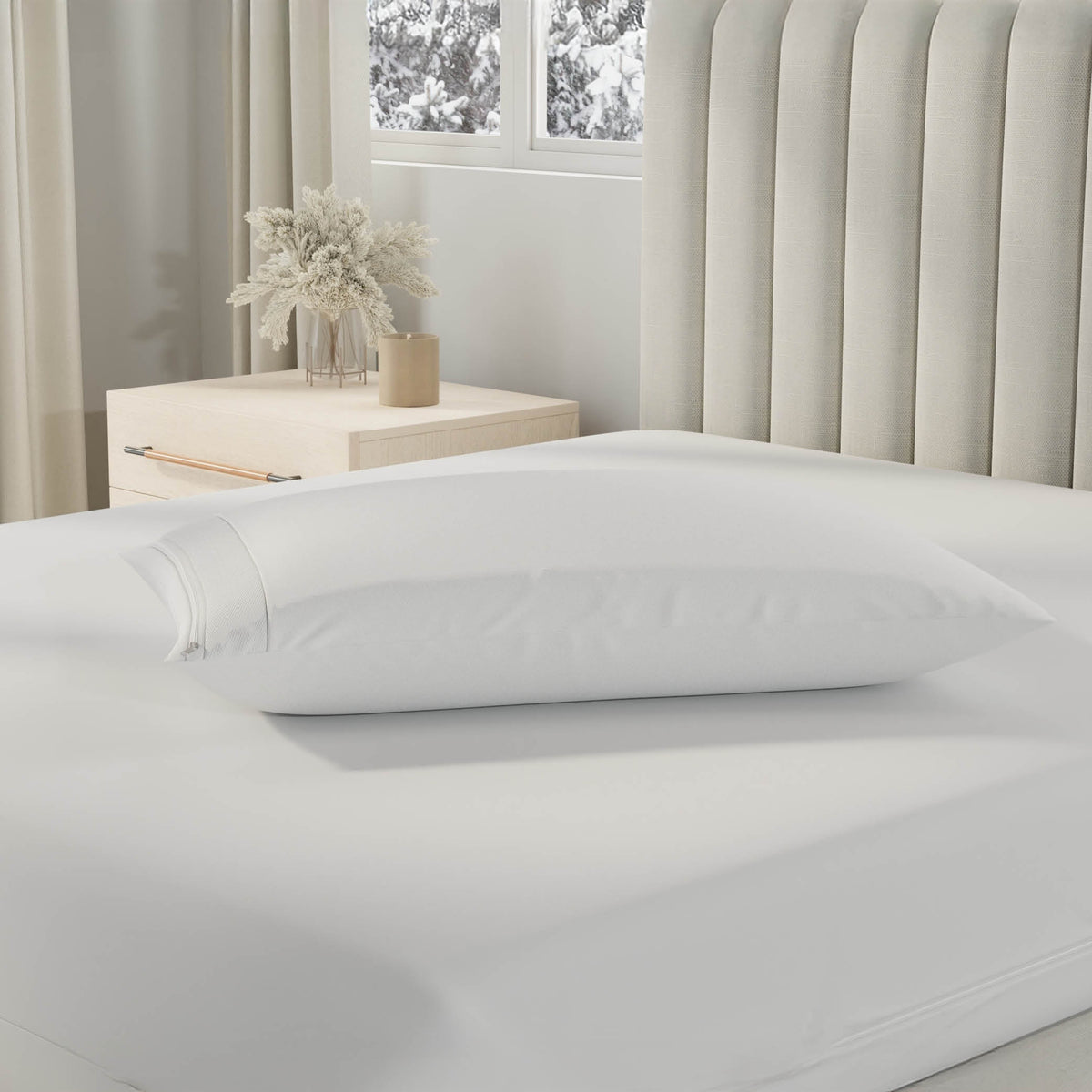 Image of a pillow with a Cooling Pillow Protector on it on top of a bed with just a Total Encasement Mattress Protector