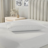 Image of a pillow with a Cooling Pillow Protector on it on top of a bed with just a Total Encasement Mattress Protector