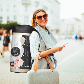 Image of a woman smiling outside with her rolled-up Sleep Kit in a bag over her shoulder