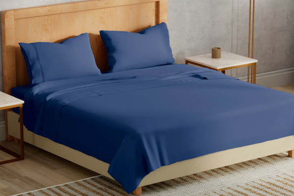 Side image of a wooden bed with Celestial Blue Refreshing sheets and pillowcases