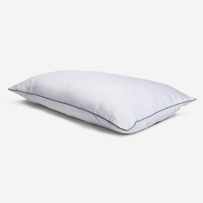 Tabletop image of the Shattered Ice Foam & Fiber Pillow with blue piping 