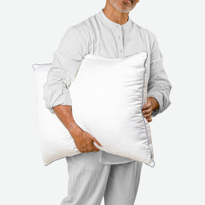 Image of a man in pajamas holding the Shattered Ice Foam & Fiber pillow