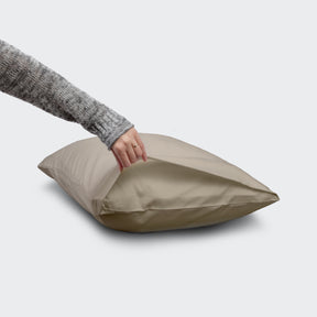 Image of a hand holding open the end of a Dove Gray Refreshing pillowcase to showcase the enveloping design