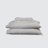 Image of Dove Gray Refreshing TENCEL™ Lyocell Sheet Set stacked top to bottom: Flat Sheet, Fitted Sheet, 2 Pillowcases