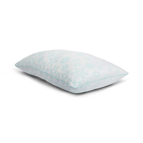 Tabletop image of the Snowflake Fiber Pillow on a white background. The pillow's cover has a light blue ombre snowflake pattern. 