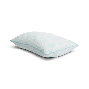 Tabletop image of the Snowflake Latex + Fiber Pillow on a white background. The pillow's cover has a light blue ombre snowflake pattern. 