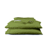 Image of a Moss Green Soft Touch TENCEL™ Modal sheet stack that includes (from top to bottom): a folded flat sheet, a folded fitted sheet, and two pillowcases on pillows
